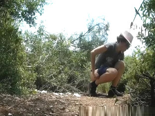 Woman With Hat Pulls Pee In Middle Of Bushes