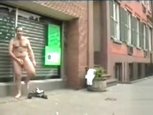 Hairy naked man masturbates on a city sidewalk