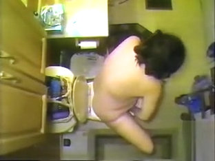 Naked maiden takes a piss in the bathroom