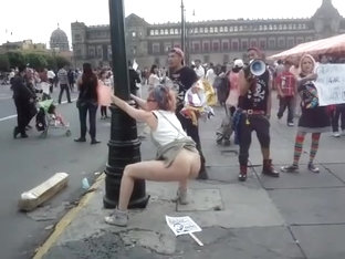 Female agitator pees and poops on a poster at a rally in protest to the government