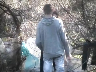 Caring boyfriend covers up girl peeing in the shrub