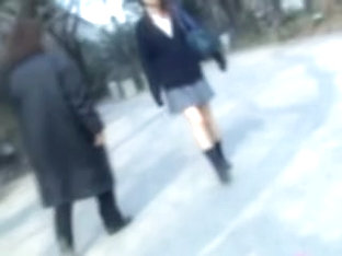 Naughty man sharking Asian college girl skirt in the street