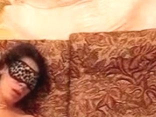 Blindfolded brunette girl with hairy pussy moans load, as she gets dildo masturbated on the sofa.