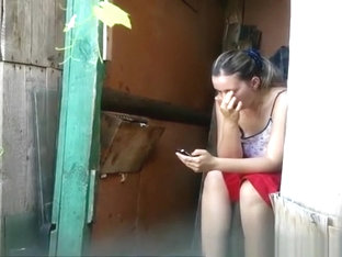 Woman takes a pee in old wood toilet