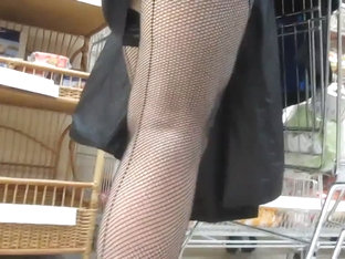 Touching her legs in a seamed fishnet stockings in market