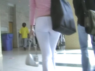 Fit brunette in white skintight pants walks in a student hall candid porn