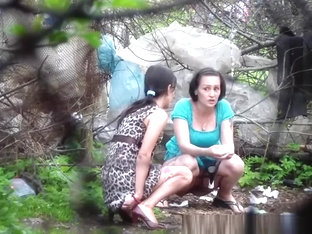 Two brunette women spied pissing outdoors