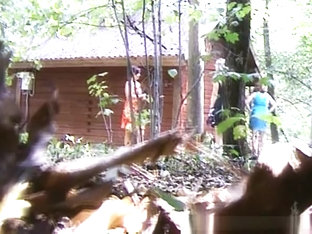 Woman In Blue Dress Pissing Next To Wood Shelter