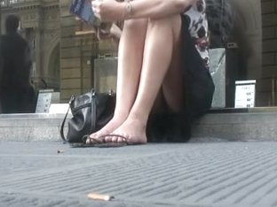Upskirt Spy Cam Shot Of A Sexy Blonde Sitting On A Curb.
