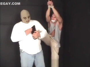 Handsome ex-military stud strung up by hs wrists gagged and stripped.