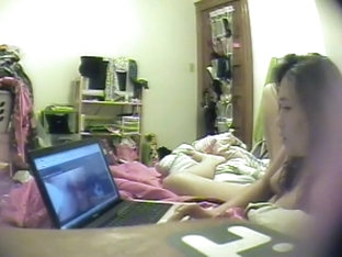 Asian girl watches porn and rubs pussy