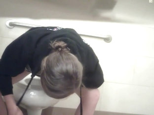 Girl pissing and stretching legs not to touch dirty bowl