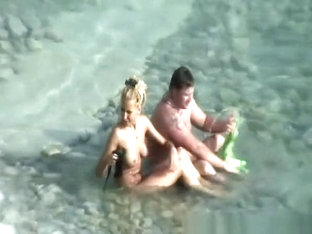 Nudist couple refreshing in water