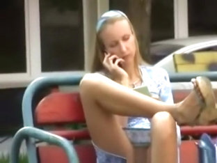 Girl seating in a bench shaved pussy upskirt