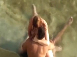 Gorgeous redhead is riding her fellow-ally on the beach
