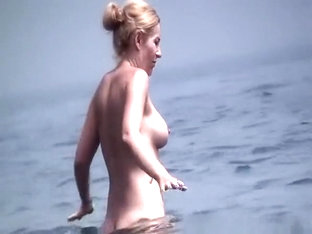 Tattooed nudist and other in beach