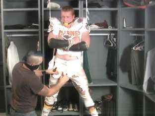 Tall redheaded football player bound gagged and stripped.