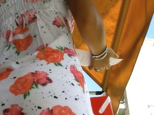 An Inquiring Camera Looks Under A White Dress With Rose Print