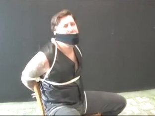 BG Beefy stud in leather vest tied to chair and gagged