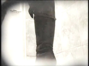 Amateur in high boots sits pissing in public toilet