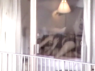 Voyeur zooms on sex in a hotel room